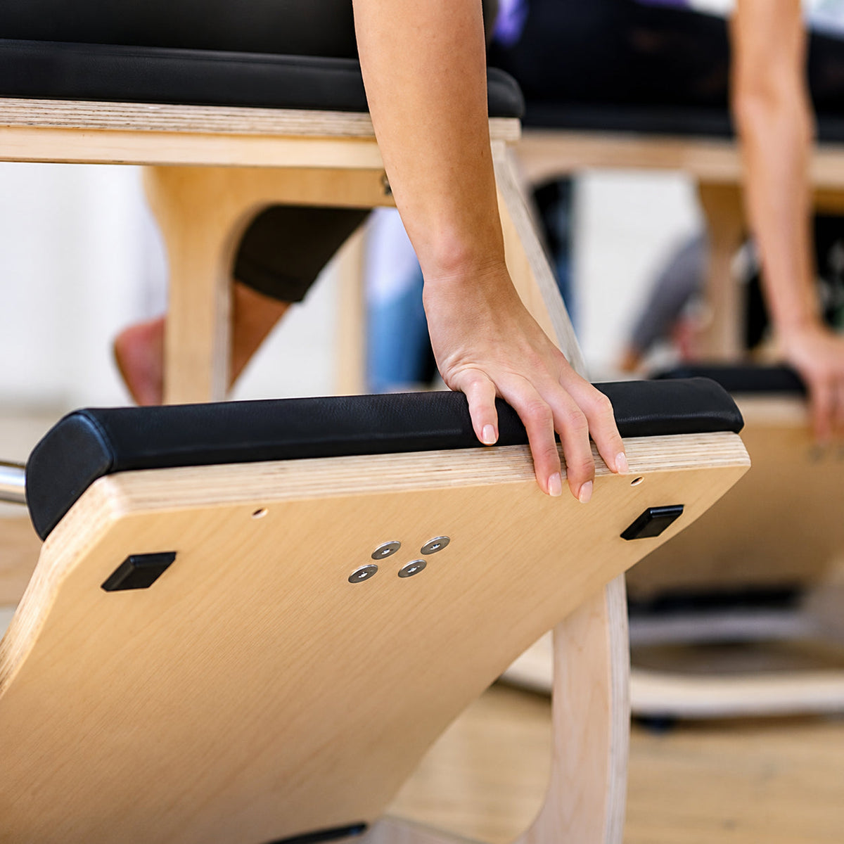 Balanced Body EXO Chair met hand op het beklede pedaal